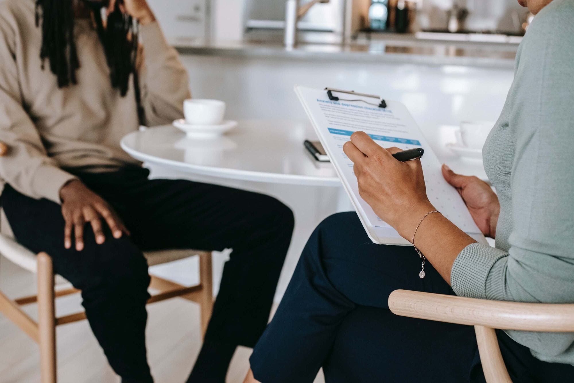 Photograph of an interview with one person holding a clipboard